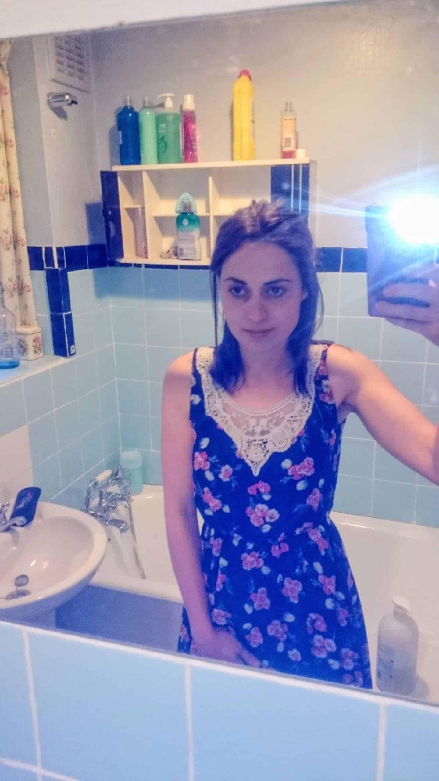 Woman in an ugly dated bathroom before ripping the tiles off