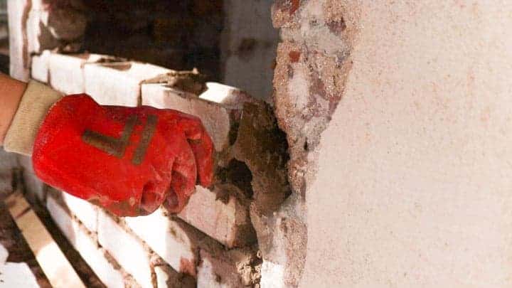 adding mortar while wearing rubber gloves