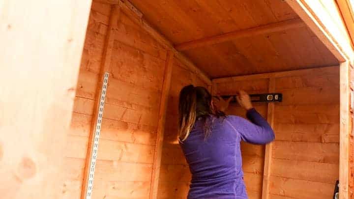 making sure twin slot system is level for shed shelves