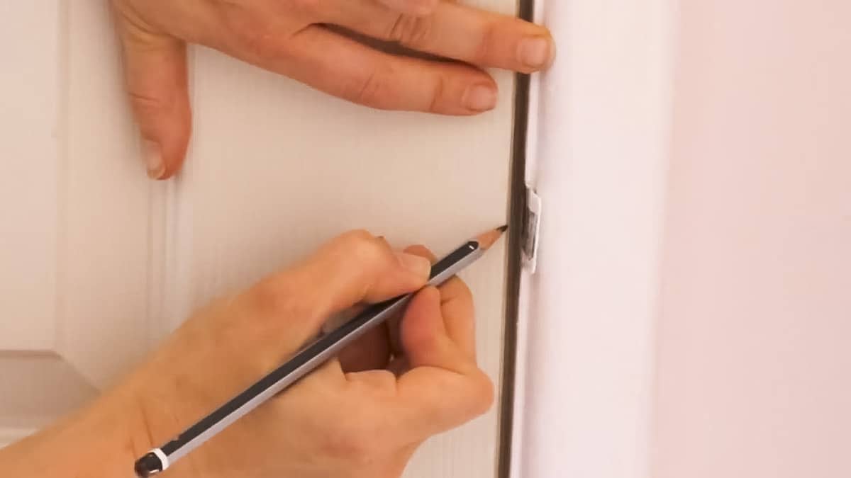 Marking centre of an existing strike plate on a new door before drilling for a new door handle
