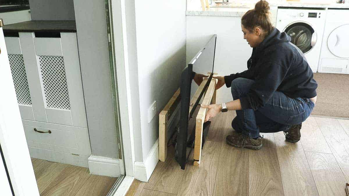 Placing timber around an LED TV to work out what depth to cut wooden slats (AKA battens or noggins)