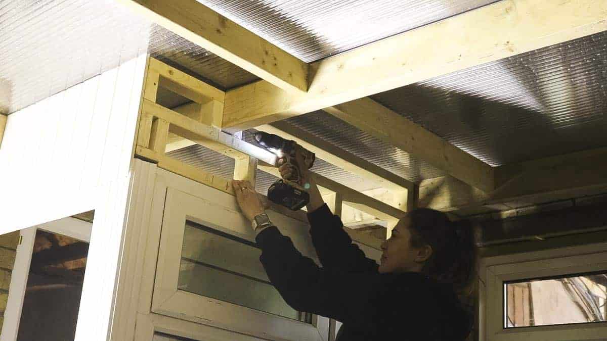 Screwing wooden frame to car port above UPVC porch