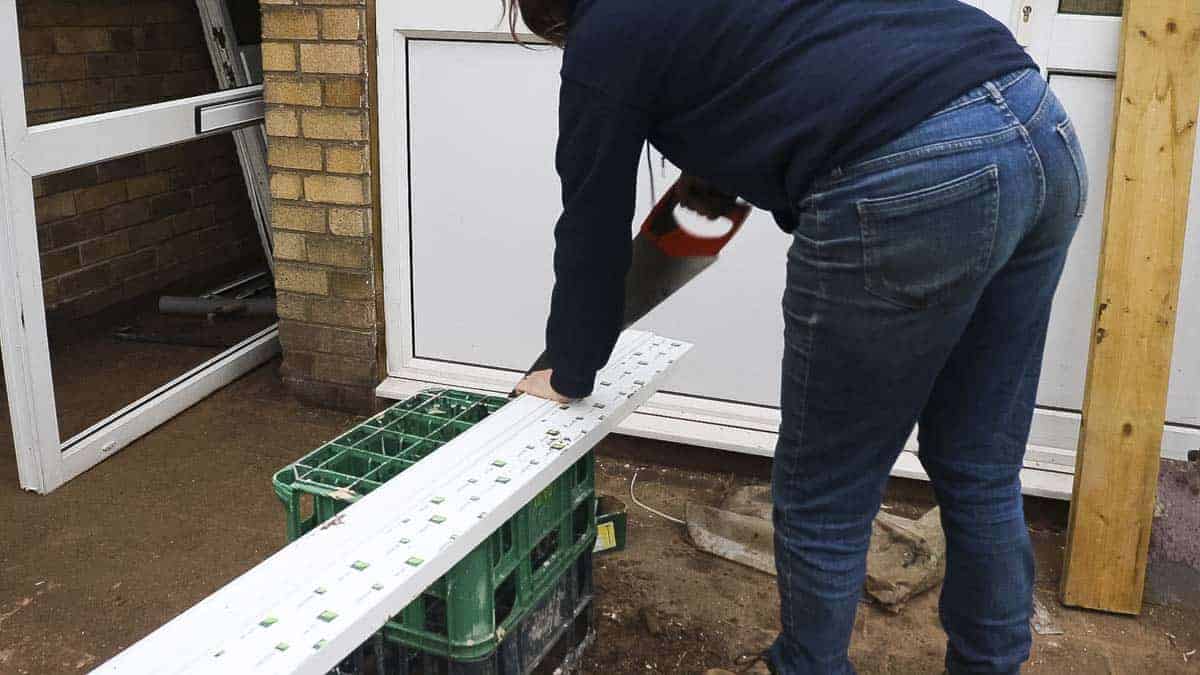 Cutting UPVC window sil with a hand saw