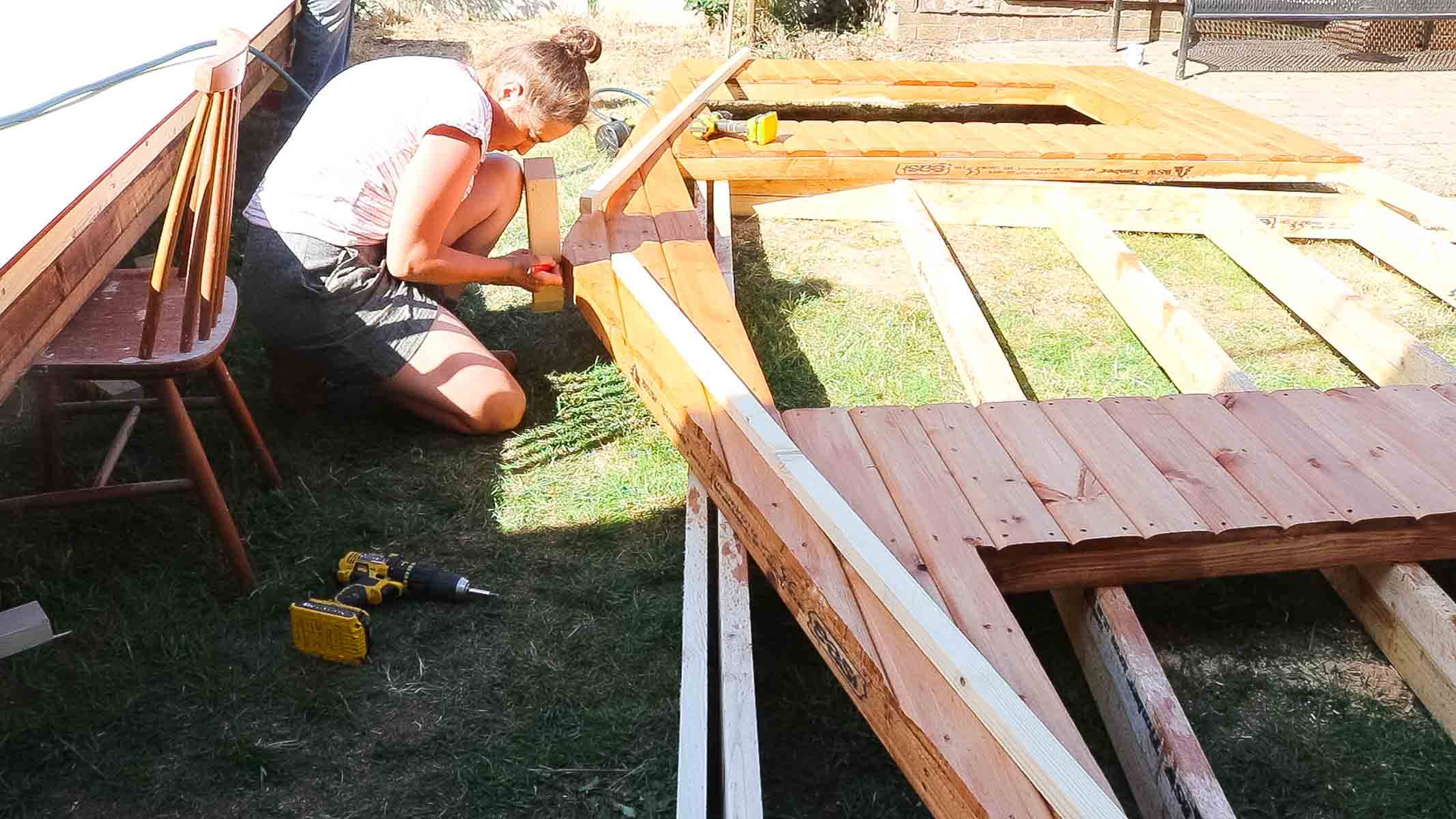 woman screwing roof locator battens on top of a summerhouse cladded shed panel