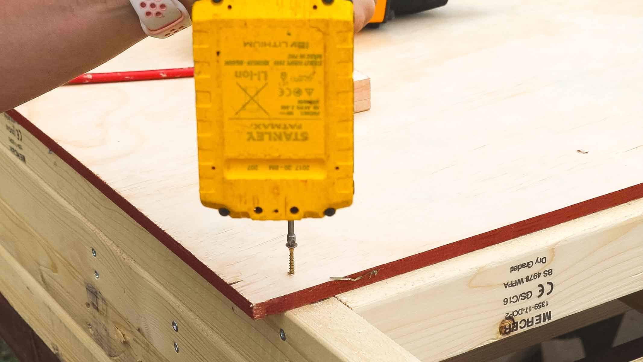 screwing timber cladding to shed frame with combi drill and screws