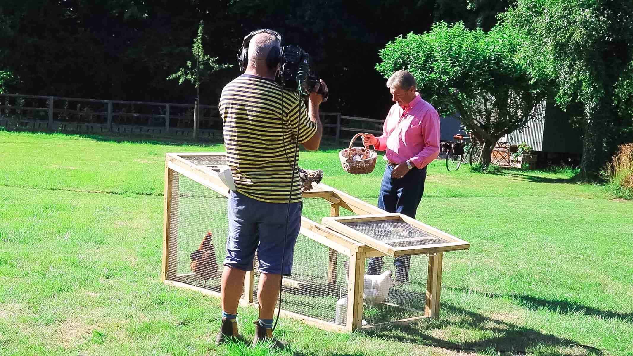 Alan Titchmarsh filming on Love Your Weekend with chickens in a pen