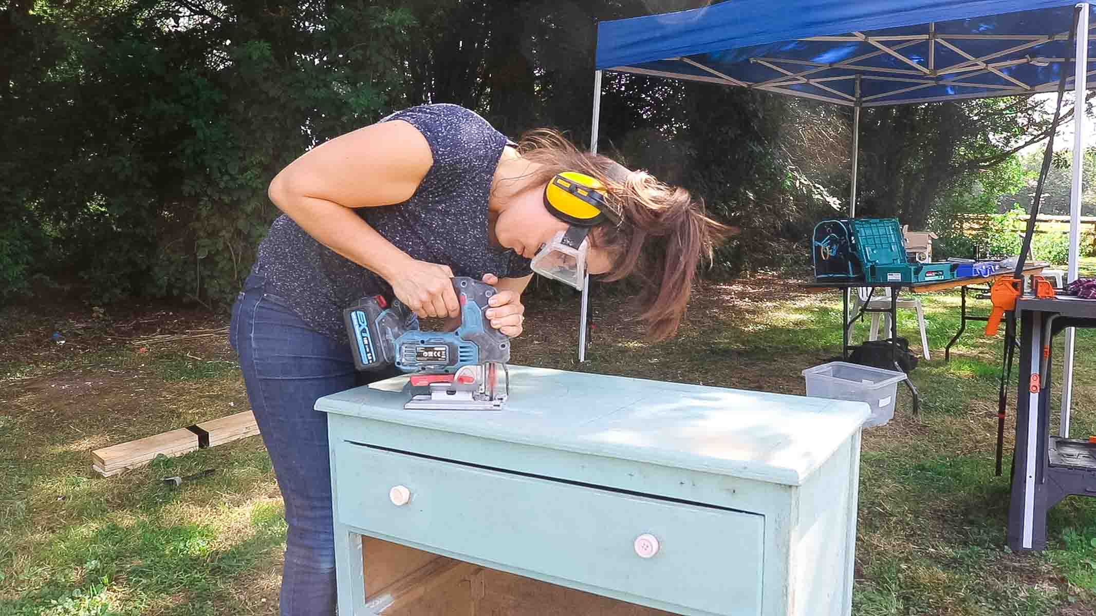 TV carpenter, Vikkie Lee, cutting a washing up bowl hole for a play sink in an old chest of drawer to upcycle furniture