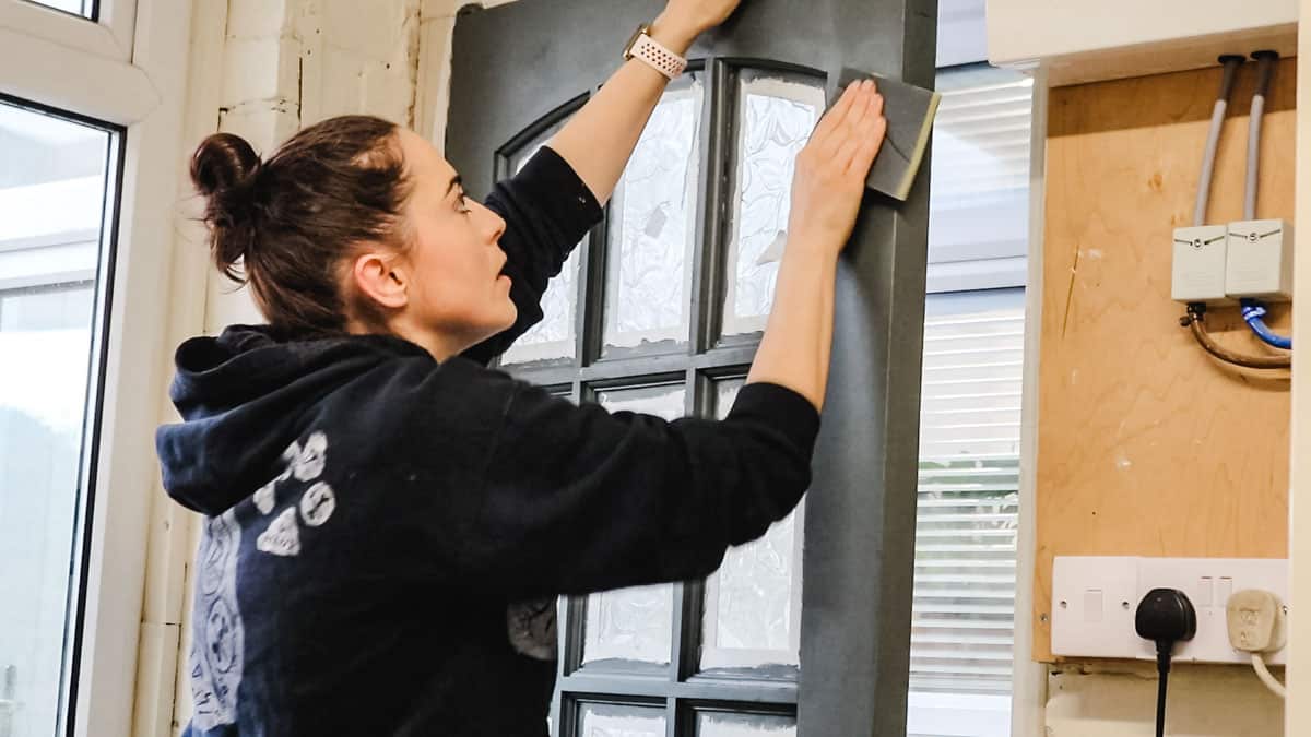 Woman sanding off flecks in paint with 220 grit flexible sanding pads