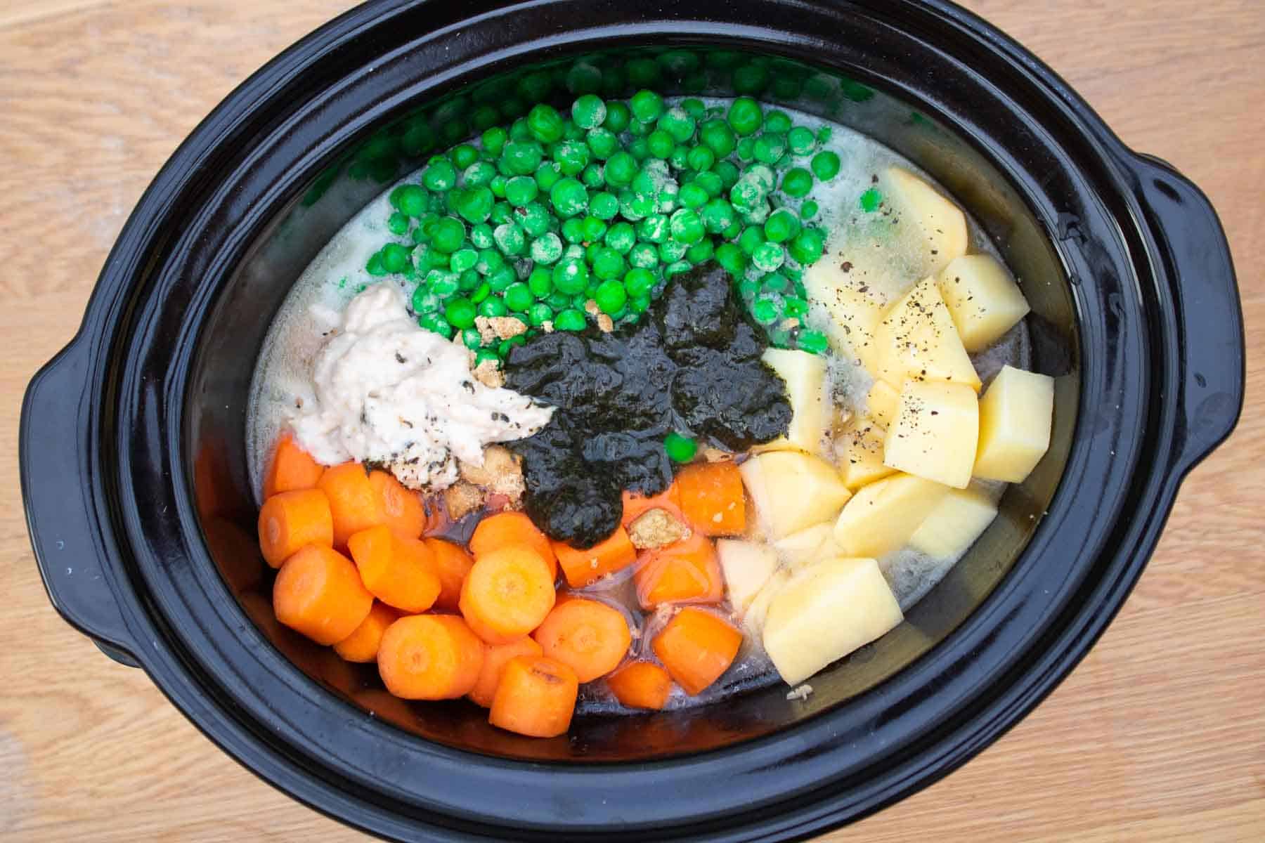 Raw lamb casserole ingredients in a slow cooker before turning on.