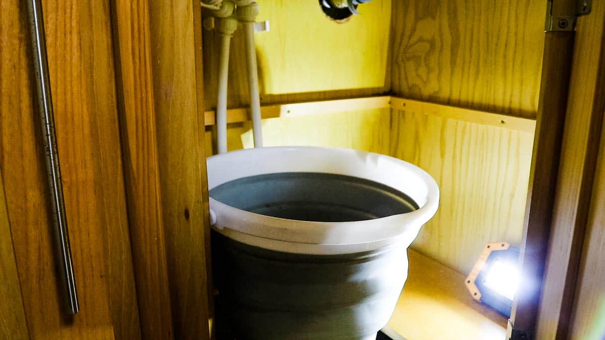 Collapsible bucket under a bathroom sink to do plumbing