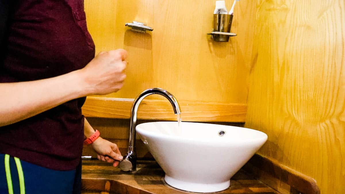 Tap turned on in a narrowboat bathroom to check the water flow