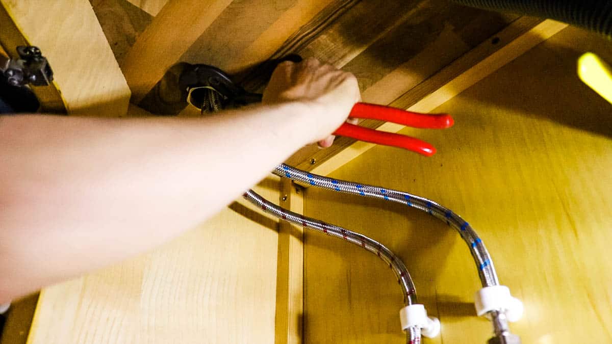 Tightening the nut under the the bathroom worktop that clamps a tap to it