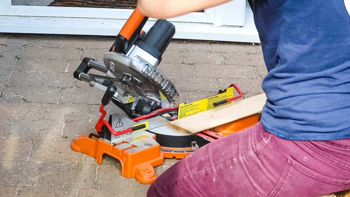 Woman using a Worx battery powered mitre saw to cut skirting board