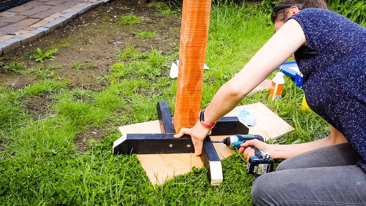 Woman screwing feet on a DIY bird table stand