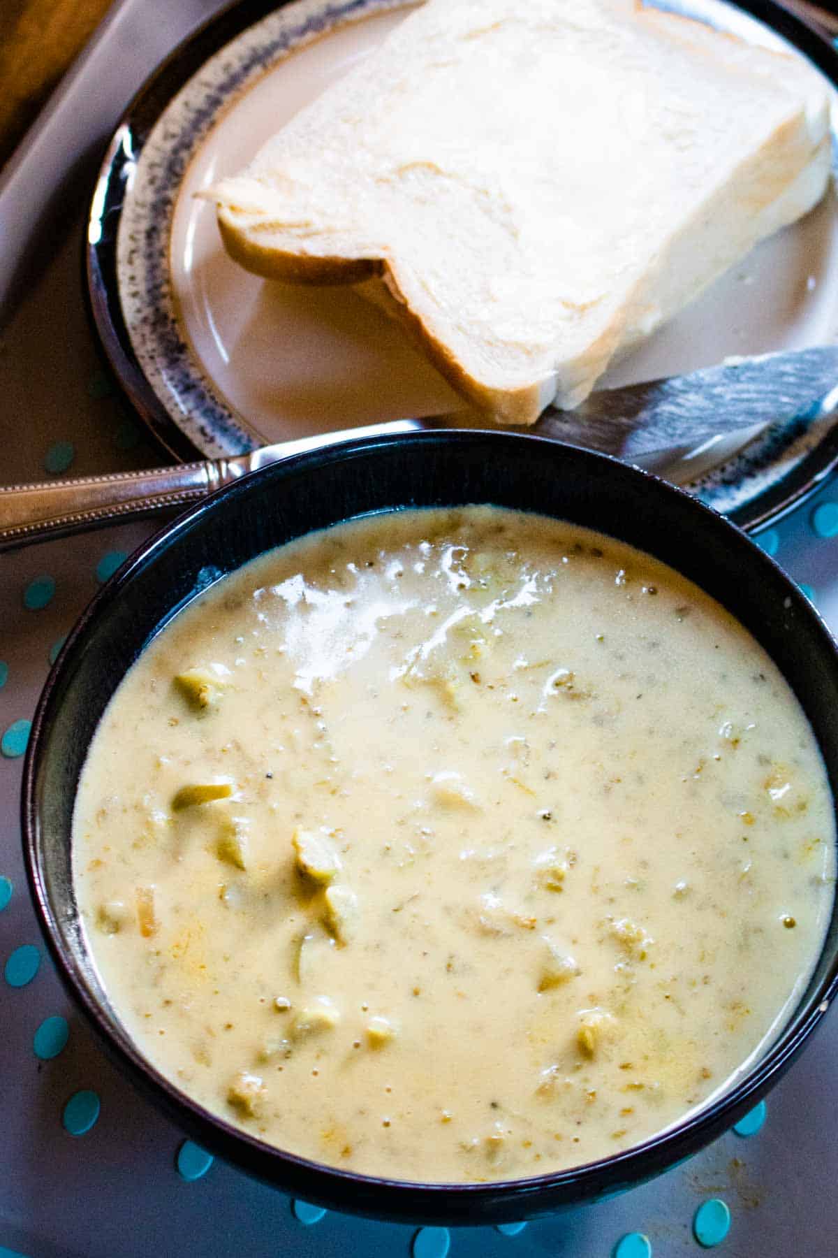 Soup in a bowl with white bread and butter