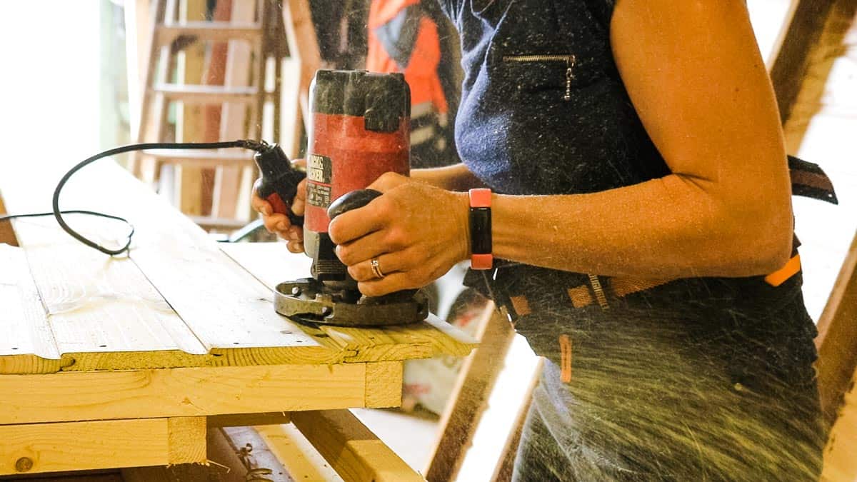 Using a Black and Decker router to cut excess cladding with flush trim router bit
