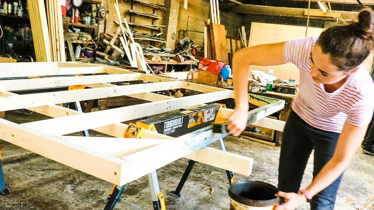 Woman treating a shed base made of CLS timber