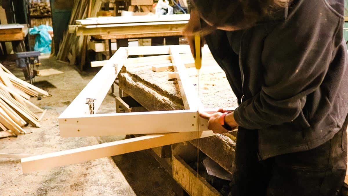 Hand sawing wardrobe framework to take home in sections