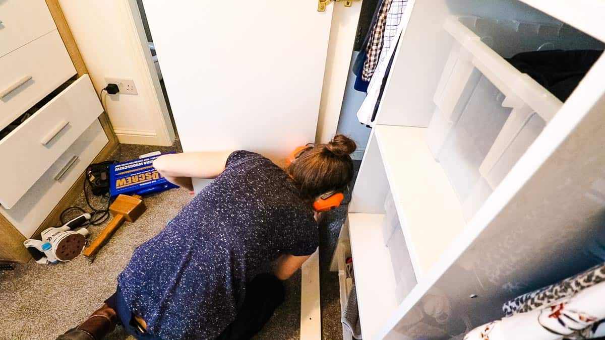 Woman hanging wardrobe doors to fitting framework