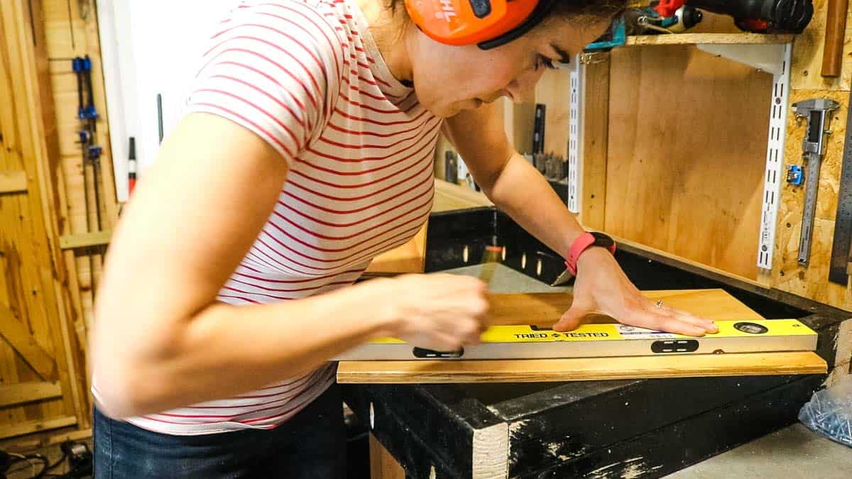 Woman using a spirit level as a straight edge