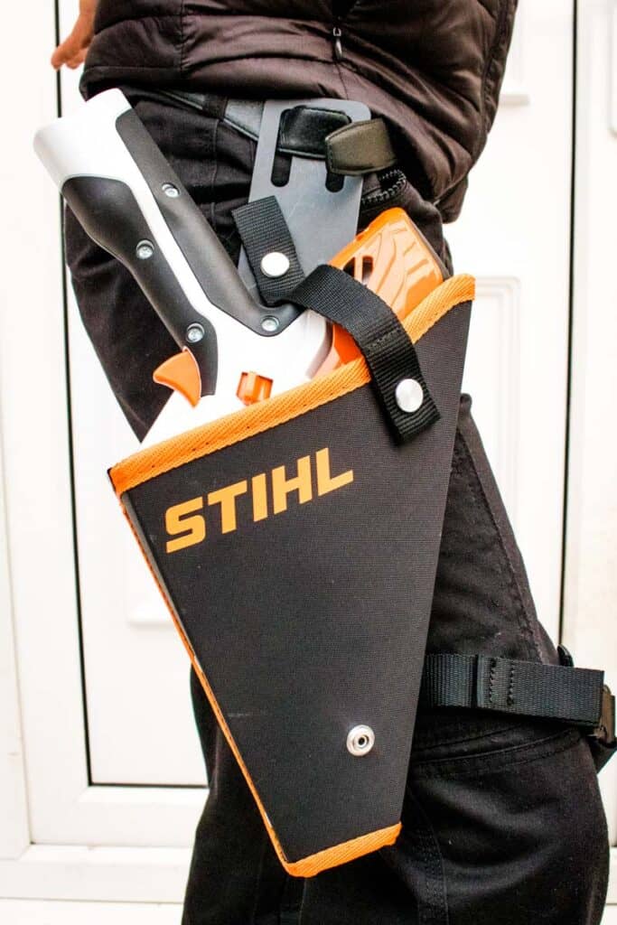 Stihl battery chainsaw in a holster attached to belt and leg