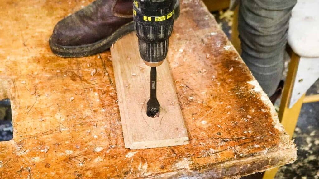 Drilling a thumb hole with a flat wood drill bit for a page holder