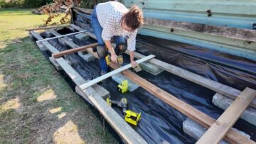 Checking the timber base with a spirit level above the supporting blocks.